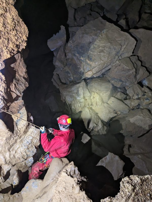 Passage d'un boyau en spéléologie dans les Pyrénées